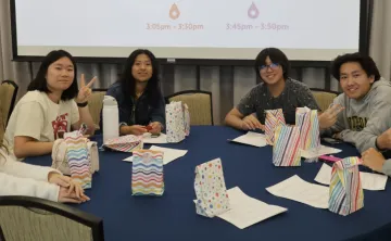 Group of youth sitting around a table smiling